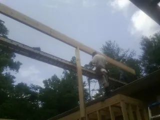 Carpenter setting a ridge beam over a new addition frame — Ice Dam Removal by Roofing Brothers in East Canaan