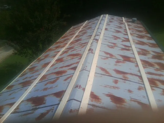 Rusted metal roof panels with new wood purlins before replacement — Storm Damage Roof Repair in East Canaan by Roofing Brothers