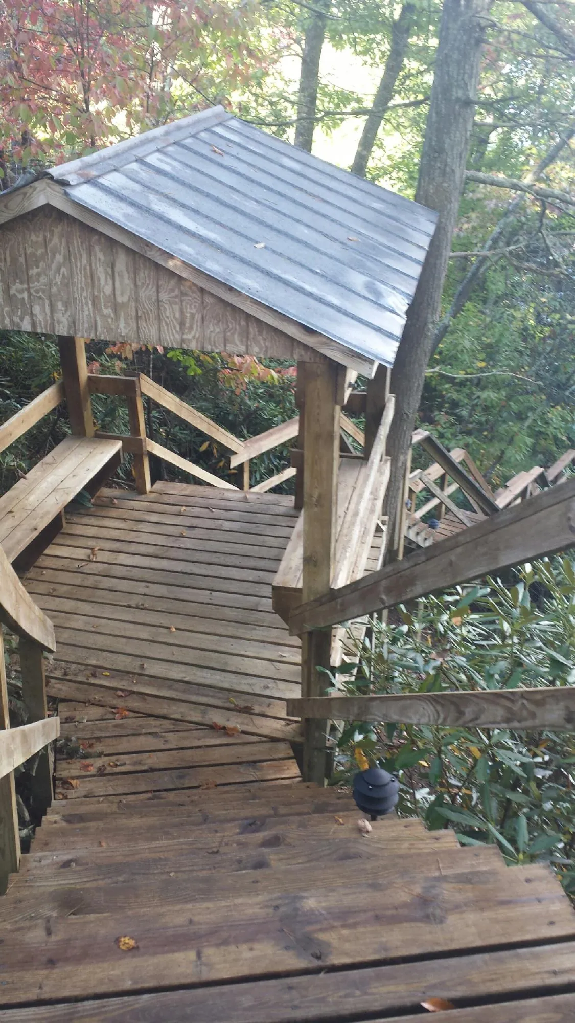 Metal roofed shelter over wooden steps on a wooded walkway — Skylight Repair & Installation work by our crew in East Canaan