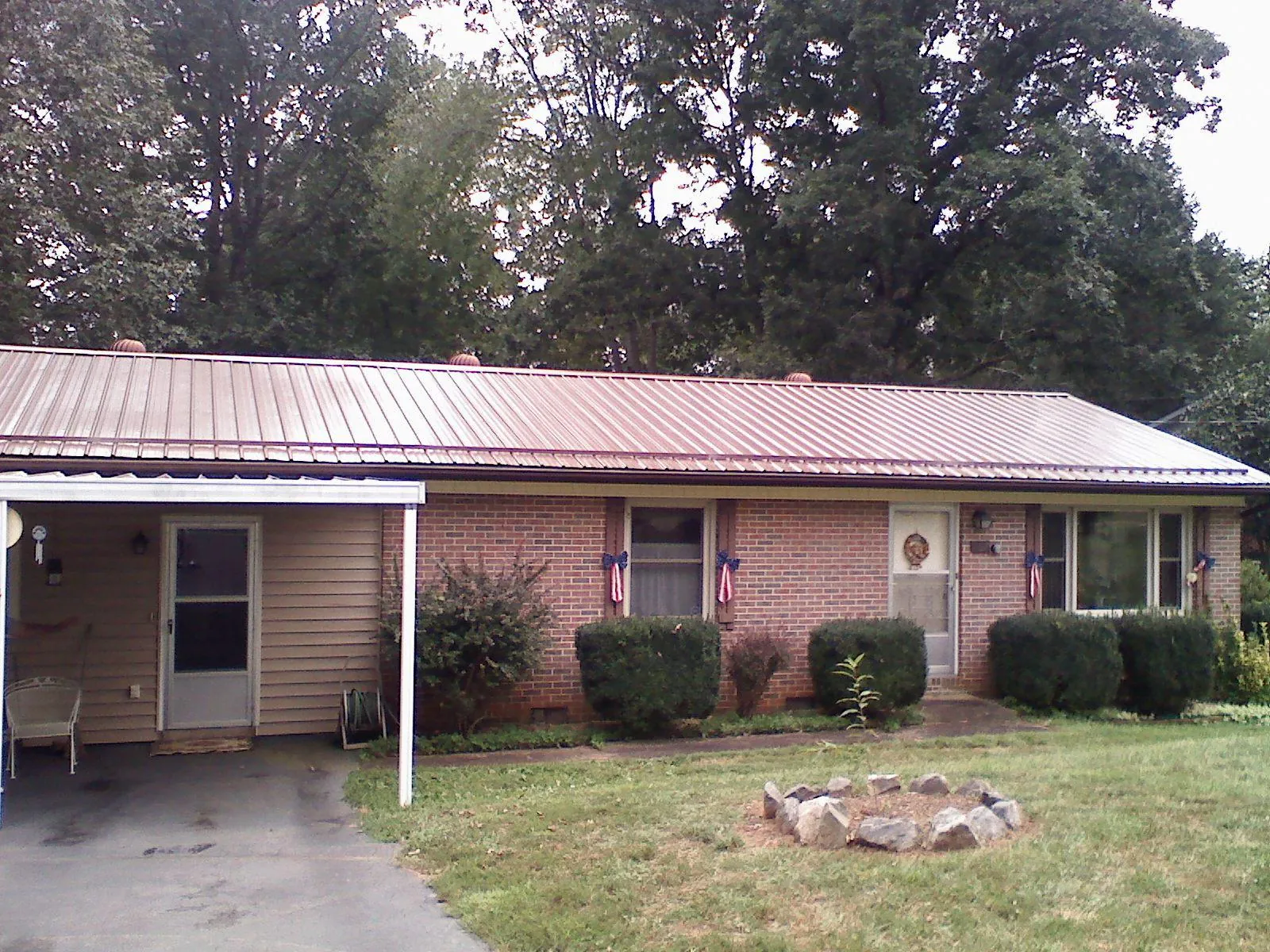 Bronze metal roof and carport on a brick ranch home — Roof Repair work by our crew in East Canaan